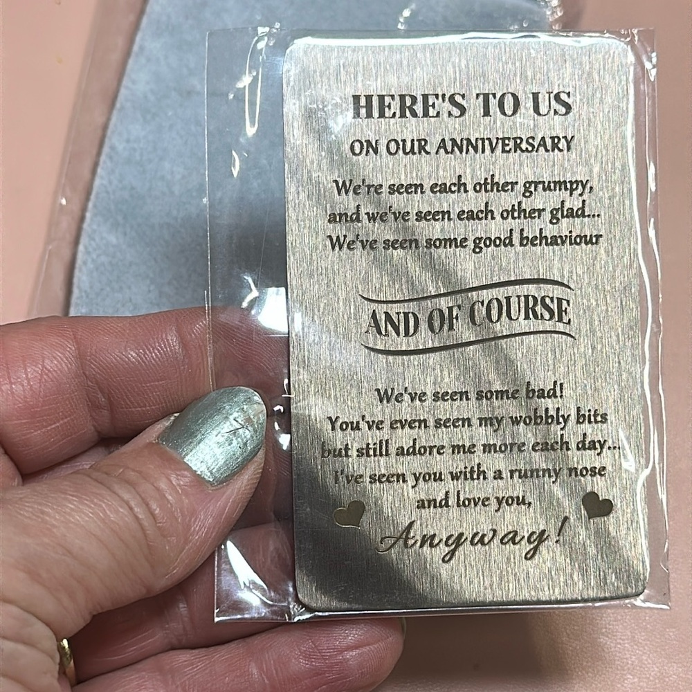 New in package anniversary metal card in a gray cloth pouch